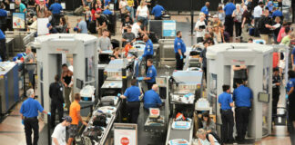 Airport security checkpoint with passengers and staff busy