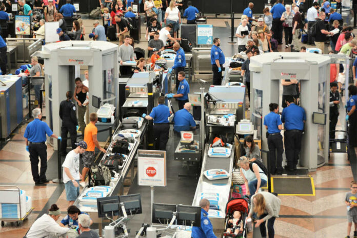 1463547920 Airport security checkpoint with passengers and staff busy