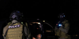 Police officers arresting a person at night