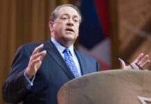 Spy Scandal Erupts: MAGA Fury Over Jerusalem Meeting Man in suit speaking at podium on stage