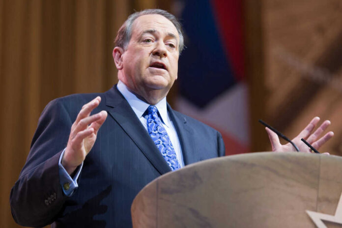 Man in suit speaking at podium on stage