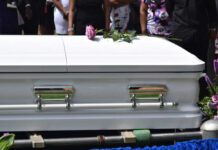 Mother Charged: Baby Found Head-First In Trash White casket with pink rose at funeral service