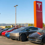 Musk’s DESPERATE Move Signals Major Disaster Tesla cars parked near red Tesla sign