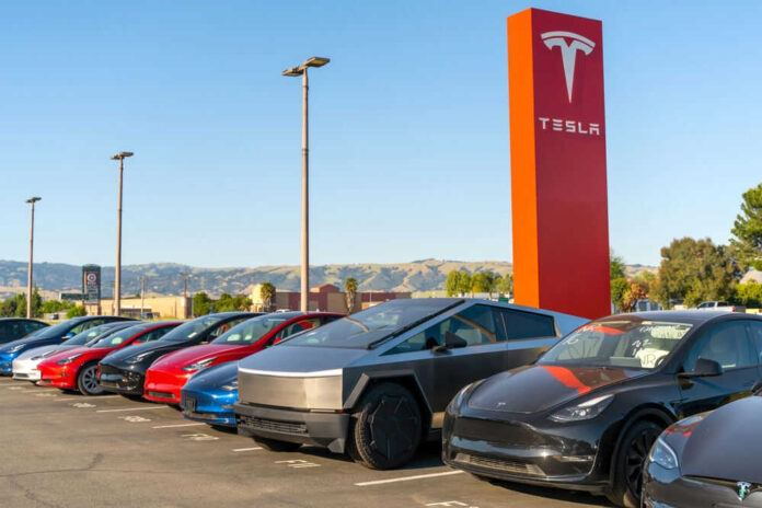 2461159891 Tesla cars parked near red Tesla sign