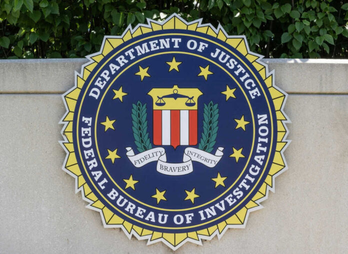 2470205085 FBI seal on stone wall with foliage background