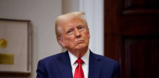 Man in suit with red tie looking contemplative