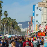 Frightening Fog Misconception Grips California Crowded Venice Beach boardwalk with palm trees and shops