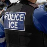 Close-up of a police officers uniform with POLICE ICE on the back