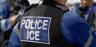 Close-up of a police officers uniform with POLICE ICE on the back