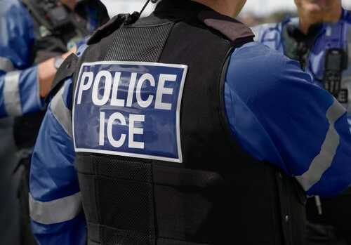 Close-up of a police officers uniform with POLICE ICE on the back