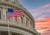 American flag and Capitol building against colorful sky